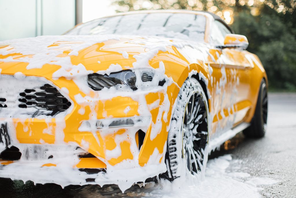 Cropped image of wheel of luxury yellow car in out