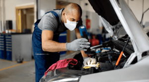 mechanic wearing autoshield ppe while working under the car hood
