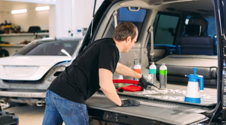 technician is deep cleaning the trunk area